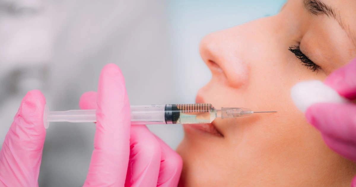 A provider at Monarch Beauty Aesthetics administering dermal fillers to restore mid-face volume.